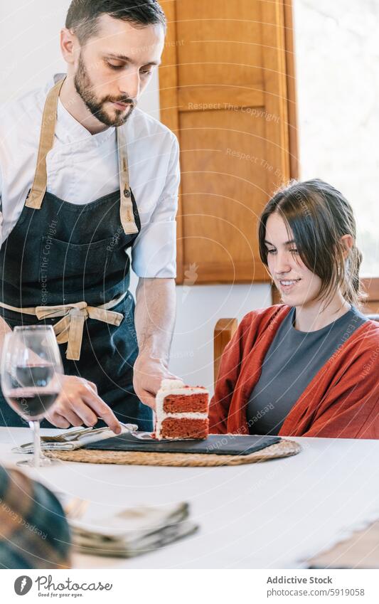 Privatkoch serviert einer Frau an einem Esstisch Kuchen privat Küchenchef Servieren speisend Tisch Blick nach unten roter Samt Dessert Wein Glas Interesse