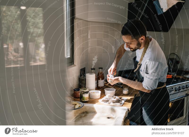 Privatkoch bei der Zubereitung frischer Fischfilets in einer sonnenbeschienenen Küche privat Küchenchef Mahlzeit Vorbereitung Essen zubereiten Lebensmittel