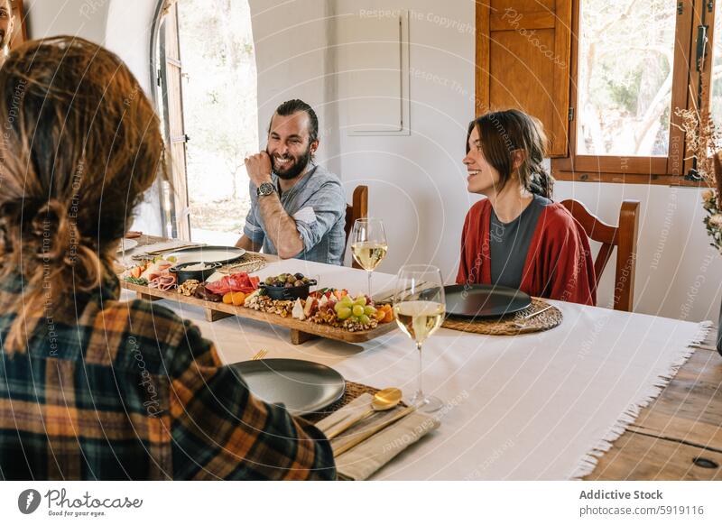 Freunde genießen eine Mahlzeit mit Privatkoch zu Hause heimwärts speisend Lebensmittel Tisch Wein Frauen Mann lachen Lächeln Wegsehen herabsehend Genuss