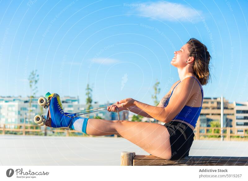 Junge Frau genießt eine Pause beim Rollschuhlaufen im Park Rollerskate Skateplatz im Freien sonnig Fröhlichkeit aktiv Lifestyle schnüren pulsierend farbenfroh