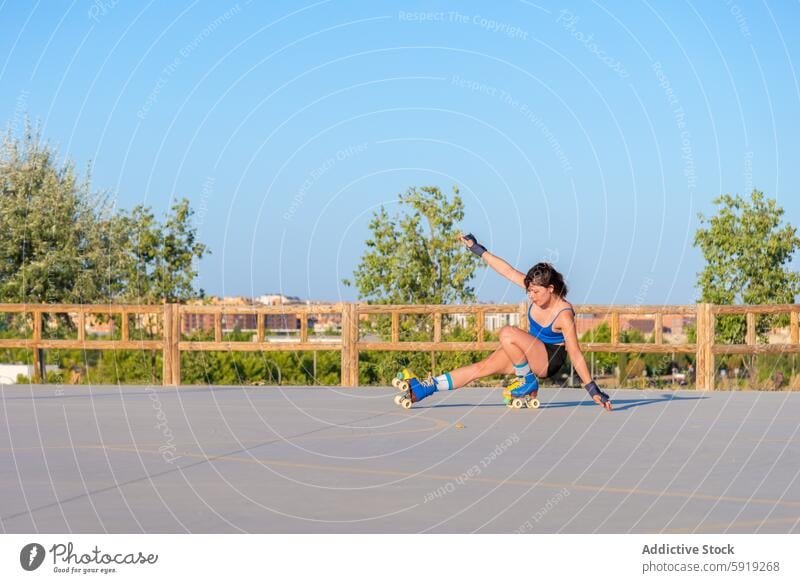 Junge Frau beim Skaten in einem städtischen Skatepark Rollerskate Tricks im Freien Athletik Fähigkeit jung energetisch Sport Schlittschuhlaufen Klarer Himmel