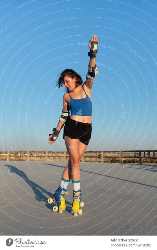 Junge Frau beim Rollschuhlaufen im Park bei Sonnenuntergang Skateplatz Blauer Himmel aktiv im Freien Fitness Sommer Sport Erholung Aktivität Jugend Freizeit