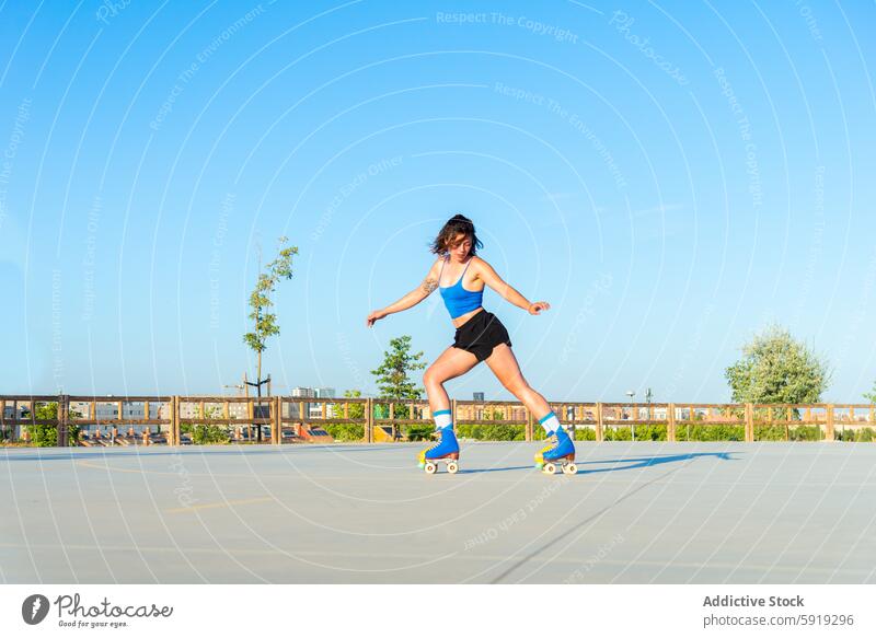 Junge Frau beim Rollschuhlaufen in einem sonnigen Skatepark im Freien Skateplatz Blauer Himmel Aktivität Sport Rollschuhe Gleichgewicht Fähigkeit