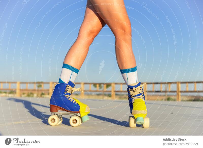 Junges Mädchen beim Rollschuhlaufen in einem sonnigen Park Rollerskate Skateplatz im Freien Jugend Aktivität Bewegung dynamisch Nahaufnahme Bein Schuhe