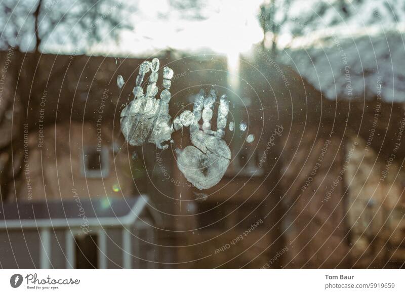 Abdrücke von Kinderhänden an der Fensterscheibe im Gegenlicht Hände Abdruck Handflächen Haus im Hintergrund Fettfinger Finger Sonnenschein Herbst berühren