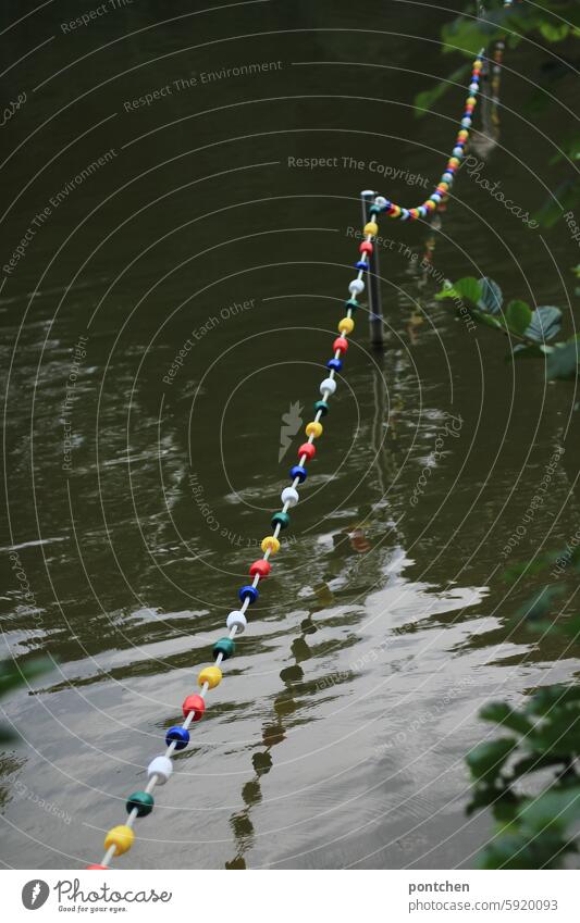 hübsche, bunte, absperrkette spiegelt sich im see. begrenzung. farbig wasser natur spiegelung Kette Absperrung Natur Sicherheit Wasser Schilder & Markierungen