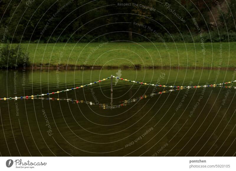 hübsche, bunte, absperrkette spiegelt sich im see. begrenzung. farbig wasser natur spiegelung Kette Absperrung Natur Sicherheit Wasser Schilder & Markierungen