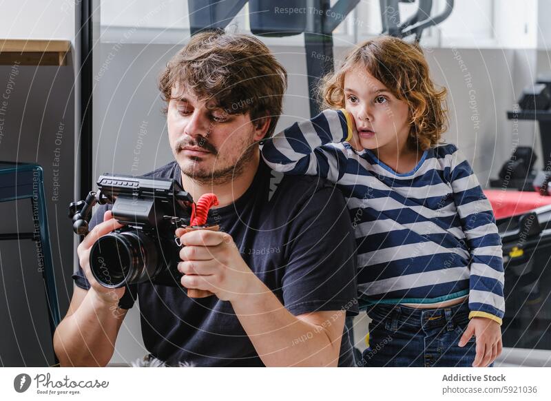 Vater und Kind teilen einen Moment mit einer Kamera Mann Fotokamera Neugier Lehnen Schulter Blick Bonden Teilen Technik & Technologie Video-Ausrüstung