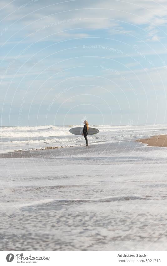 Frau mit Surfbrett am nassen Strand stehend Küste Ufer Hobby Aktivität Zeitvertreib Sport MEER Wasser Gezeiten winken Hafengebiet Seeküste Natur Meeresufer