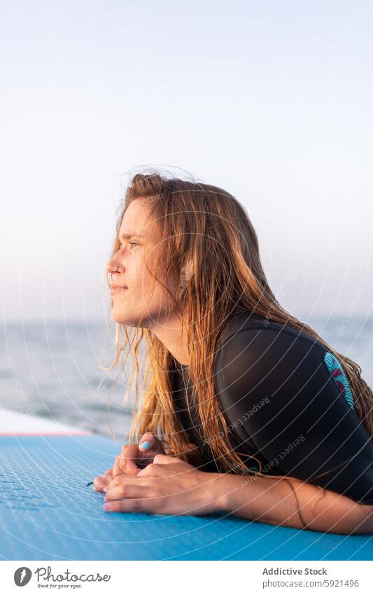 Frau schwimmt auf Paddleboard im Meer Surfer Paddelbrett Zusatzplatine SUP MEER Schwimmer schwimmen Surfbrett Sommer Holzplatte Wasser Lügen Badebekleidung