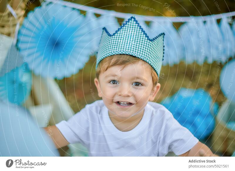 Kleinkind feiert mit Luftballons und Dekorationen im Freien Junge Lächeln Feier Krone kariert blau weiß Dekoration & Verzierung Party Glück niedlich Kind Freude