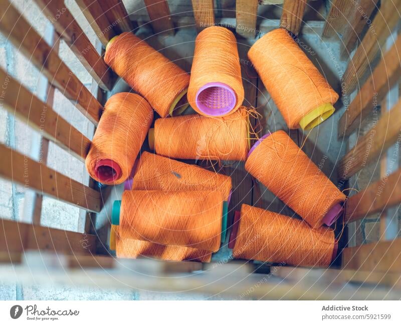 Leuchtend orangefarbene Garnspulen in industrieller Umgebung Spule Textil Fabrik Material Faser Sehne Gewebe Inszenierung Herstellung Basteln stricken