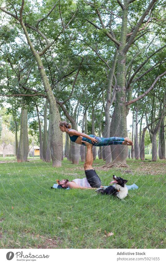 Paar übt Acroyoga im grünen Park bei Tag üben Asana Akro-Yoga Wellness Gleichgewicht Zusammensein Harmonie Wohlbefinden Pose Frau Aktivität Sportkleidung