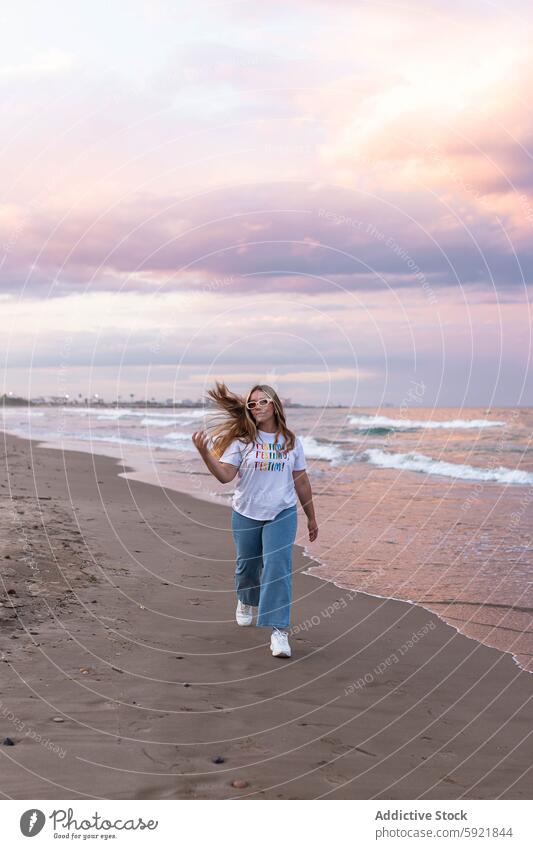 Inhalt stilvolle Frau zu Fuß am Strand im Sonnenuntergang Stil jung trendy Sommer Spaziergang positiv MEER Sonnenbrille Seeküste Glück heiter selbstbewusst