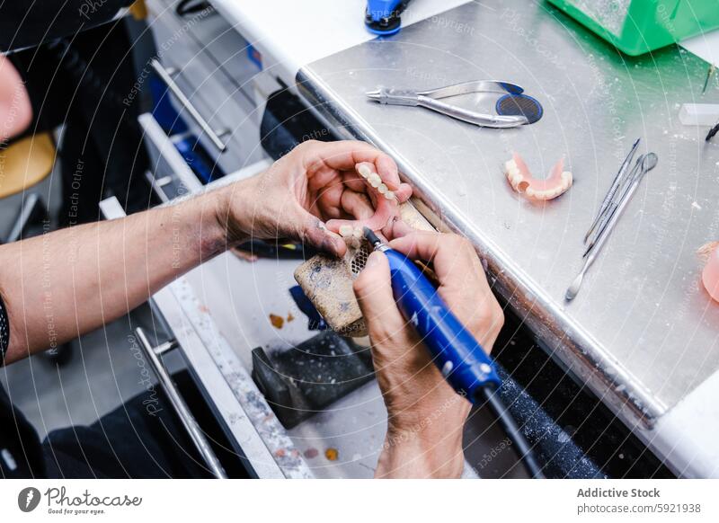 Anonymer Zahntechniker bei der Herstellung von Zahnersatz in einem Labor dental Techniker Werkzeug Handwerk Arbeit Prothesen Nahaufnahme