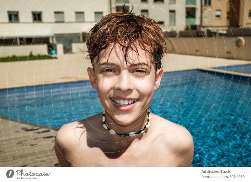 Glücklicher Junge lächelt am Pool an einem sonnigen Tag Kind Lächeln Schwimmsport Wasser im Freien Sommer Fröhlichkeit nass Behaarung Panzer Halskette