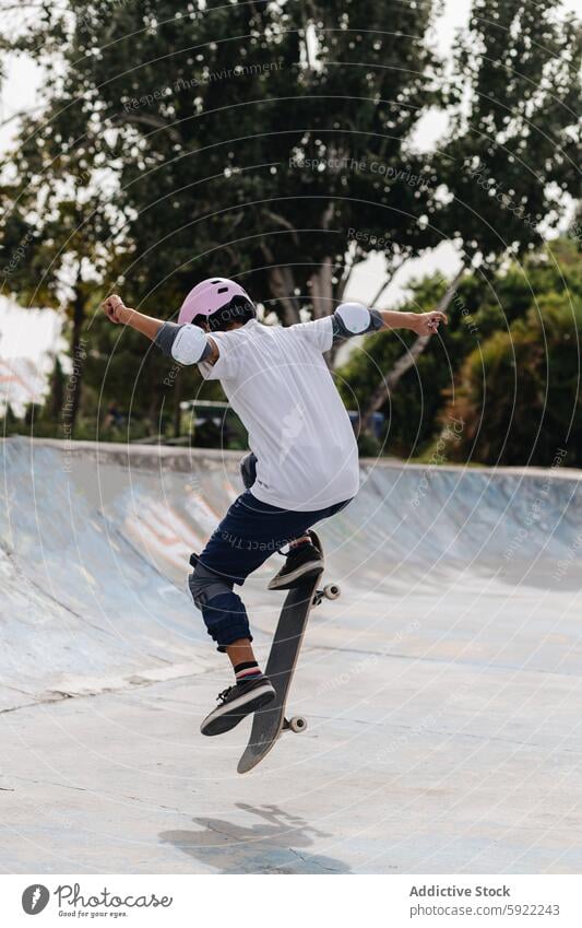 Junge Person mit Skateboard im Skatepark behüten Skateplatz Mitfahrgelegenheit Training Hobby Skater Schutzhelm extrem Bewegung Schlittschuh Energie Rampe Pool