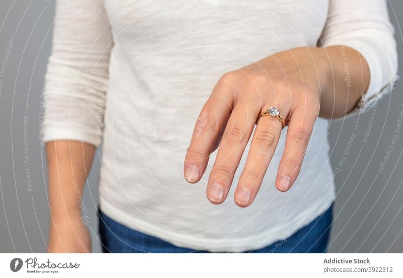 Anonyme Nahaufnahme einer Hand, die einen eleganten diamantenen Verlobungsring zeigt, der Engagement und Luxus symbolisiert Ring Diamant Finger Schmuck Reichtum