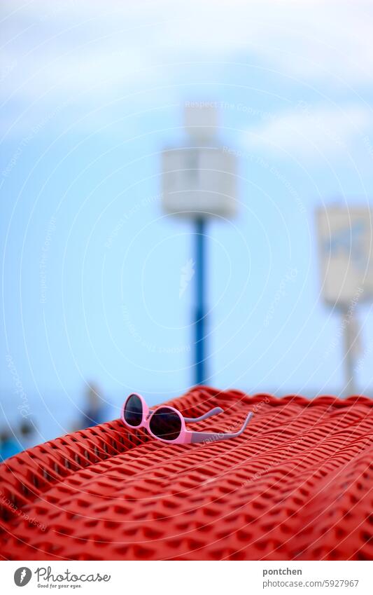 eine pinke sonnenbrille liegt auf einer roten strandmuschel. meer urlaub Ferien & Urlaub & Reisen Meer Sand Küste Tourismus Himmel nordsee unschärfe uhr