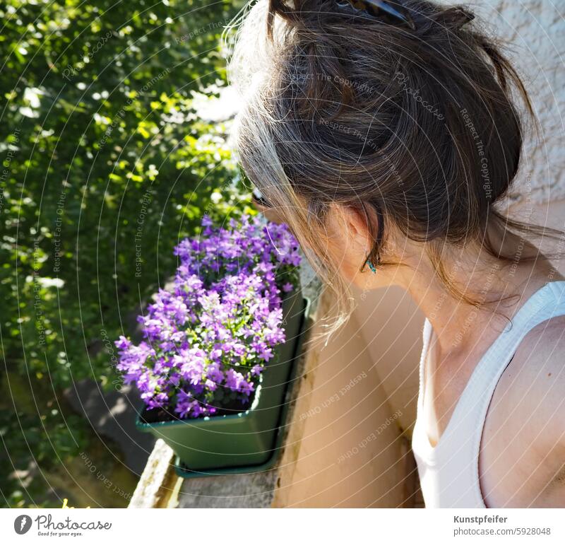 Frau blickt vom Balkon herab in den sonnigen, warmen Morgen. Sommer sommerlich morgen Morgens morgenstimmung aufstehen Tagesbeginn freizeit entstpannt lässig