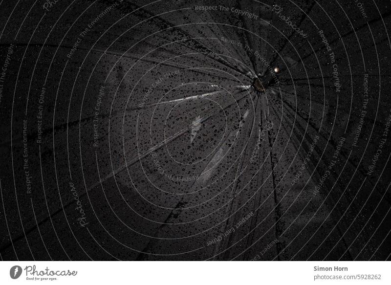 schwarzer Regenschirm, auf dem nach einem Regen Wassertropfen zu sehen sind nass wasserabweisend Regenschutz Kontrast schlechtes Wetter Herbst Regenwetter