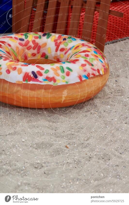 ein donut am strand vor strandkorb. schwimmerinnen schwimmreifen humor rot sand nordsee urlaub Ferien & Urlaub & Reisen Tourismus Erholung kitschig