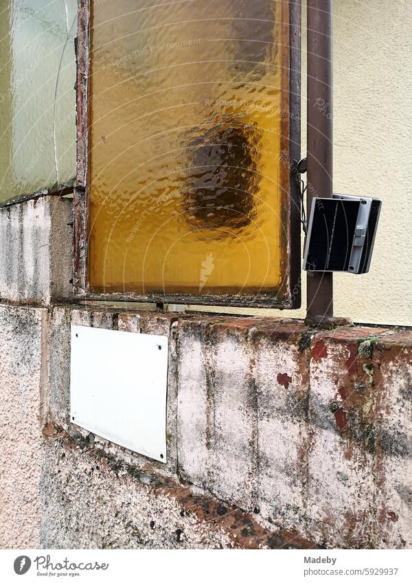 Fenster aus Riffelglas mit gelber Färbung und moderner Überwachungstechnik eines alten Wohnhaus im Ortsteil Gleiberg in Wettenberg Krofdorf-Gleiberg bei Gießen in Hessen