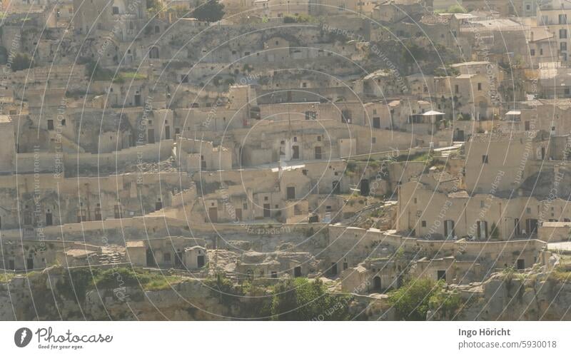 Blick auf die Altstadt von Matera (Süditalien) die sich einen Hügel hinaufzieht. Die gesamte Fläche des Fotos ist von uralten Häusern aus Natursteinen gefüllt, kein Himmel. Die Häuser wirken verlassen und menschenleer.