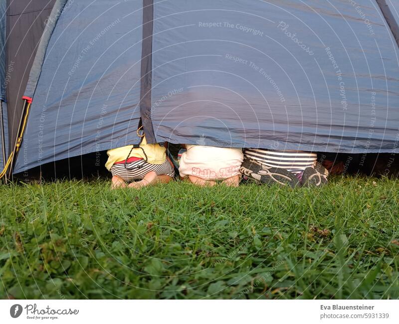 Kinderfüße und Popos lugen aus Spalt bei Zelt Zelten fuesse Camping Spalte hervorlugen Gras Wiese Ferien & Urlaub & Reisen Campingplatz grün Abenteuer Sommer