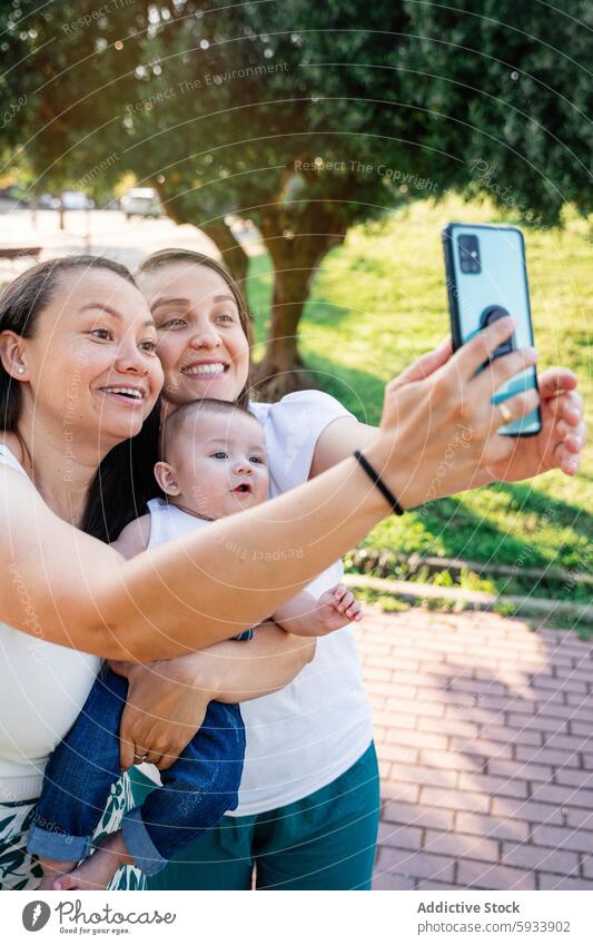 Lesbisches Paar mit ihrem Sohn bei einem Selfie im Freien lesbisch Park Freude Familie Fröhlichkeit Smartphone Baum Frau Mutter Kind Bonden