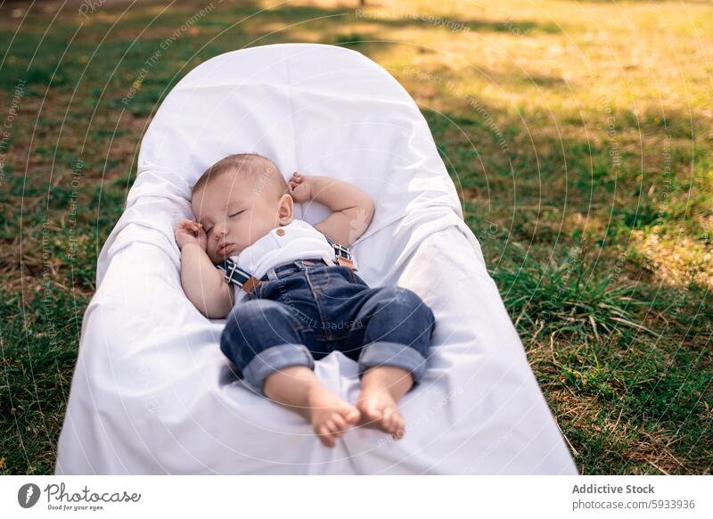 Familienausflug mit schlafendem Kind in einem ruhigen Park Gelassenheit Decke Windstille Sonnenschein Gras im Freien ruhen friedlich Baby Erholung Bonden Natur