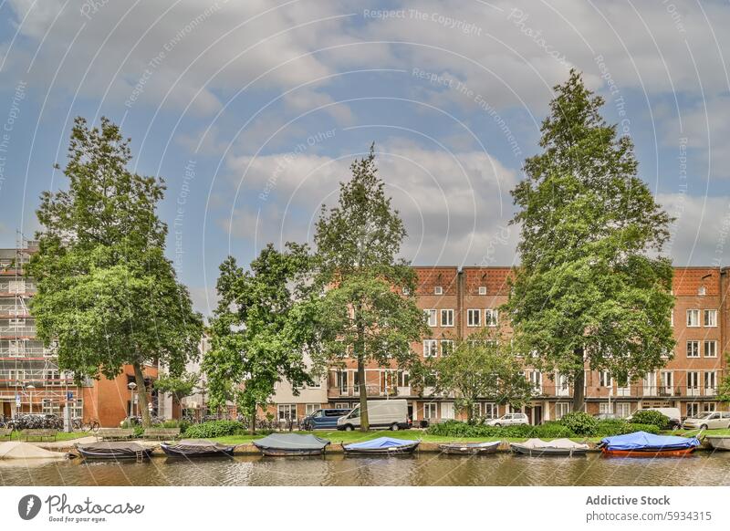 Malerischer Blick auf den Kanal mit vertäuten Booten und Wohnhäusern wohnbedingt Gebäude Himmel Cloud Baum Wasserstraße Gelassenheit urban Natur im Freien