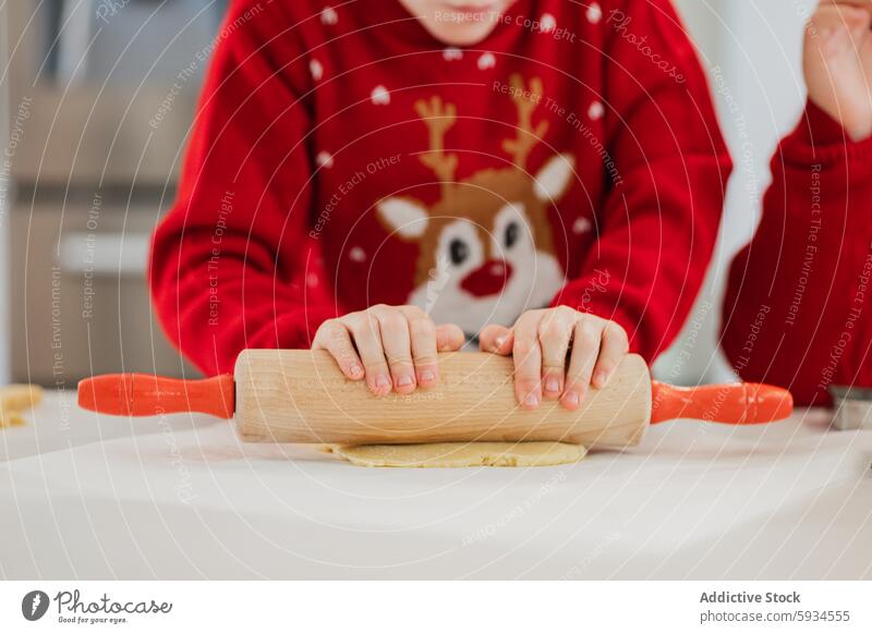 Zwillinge backen zu Weihnachten in festlichen Pullovern Kind Teigwaren Küche Feiertag Rentier Essen zubereiten Arbeitsplatte Mehl Nudelholz Familie Aktivität