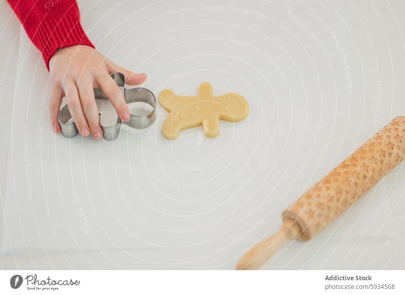 Ein Kind backt Weihnachtsplätzchen in festlicher Kleidung backen Weihnachten Keks Kutter Nudelholz Feiertag Küche Essen zubereiten selbstgemacht Freude