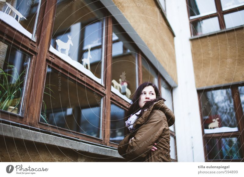 Hofaufsicht feminin Erwachsene 1 Mensch 18-30 Jahre Jugendliche Haus Gebäude Fassade Fenster beobachten stehen Traurigkeit kalt braun Wachsamkeit Neugier