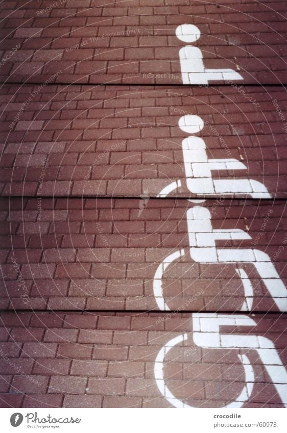 rollstuhlparkplatz Rollstuhl Behinderte unfair rot weiß gemalt Lomografie Schmerz benachteiligt Straße Farbe Pflastersteine
