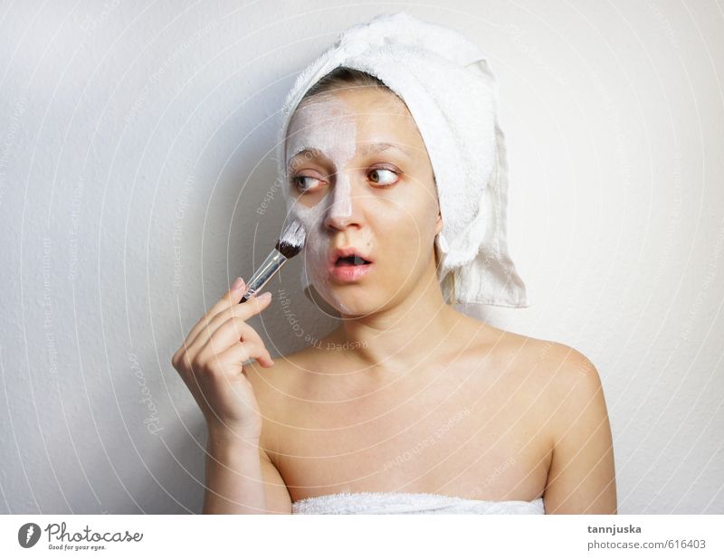 Junge, glückliche und schöne Frau, die eine Gesichtsmaske aus Ton aufträgt. Reichtum Freude Glück Körper Haut Schminke Behandlung Wellness Erholung Spa