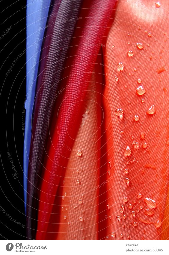 Regenschirm rot nass mehrfarbig Stoff Textilien regendicht wasserdicht Wasser Herbst Wetter wetterfest feucht Makroaufnahme Nahaufnahme orange Wassertropfen