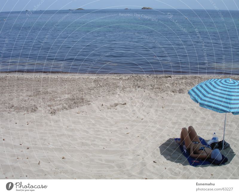Relaxing unterm Schirm Meer Strand Ibiza Wellen grau weiß beige hell-blau Frau Liege Bikini Mütze Sonnenstrahlen Sonnenbad braun Erholung schlafen Sonnenschirm