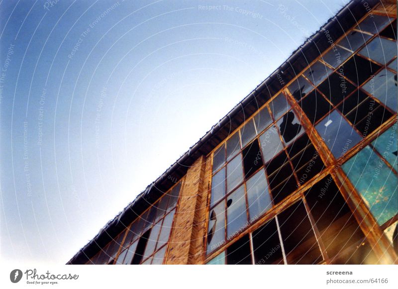 Invincible Haus Backstein Fenster kaputt Reflexion & Spiegelung rot Wolken Industriefotografie Glas Fensterscheibe Zerstörung blau orange Himmel Lomografie