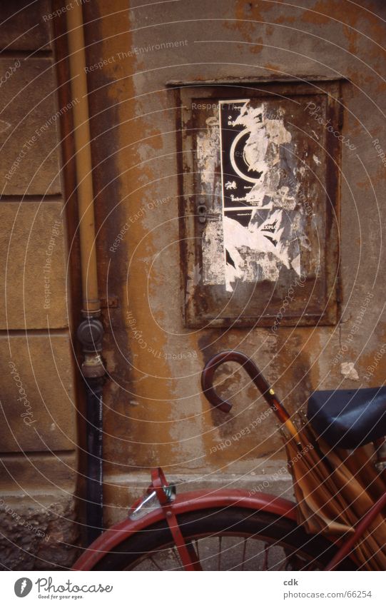 Gemälde | Fahrrad mit Regenschirm vor alter Hauswand | Ton in Ton. Wand Mauer Gemäuer Putz Plakat plakatieren malerisch Verfall Stillleben vergessen Ocker beige