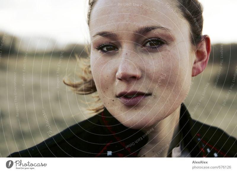 Außenportrait einer jungen Frau bei Wind Junge Frau Jugendliche Gesicht 18-30 Jahre Erwachsene Jacke brünett langhaarig Sommersprossen beobachten Kommunizieren