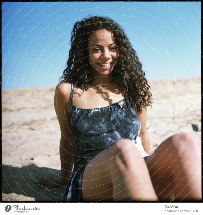 freut sich! Ausflug Stranddüne Junge Frau Jugendliche Haare & Frisuren Gesicht Beine Knie 18-30 Jahre Erwachsene Kleid schwarzhaarig langhaarig Locken Lächeln