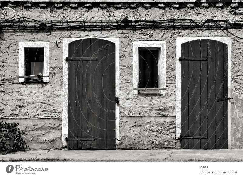 zwei türen, zwei fenster ruhig Haus Tür Fenster Wand Putz Architektur Detailaufnahme Frieden Schwarzweißfoto b/w b&w Hütte symetrie symetrisch
