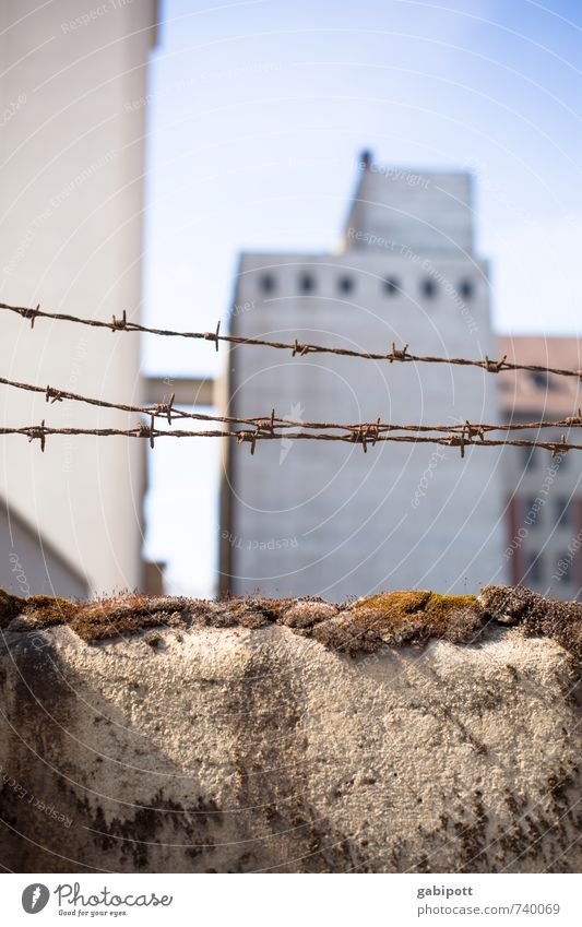 Begrenzte Freiheit Stadtrand Haus Industrieanlage Mauer Wand Fassade Stacheldraht Stacheldrahtzaun bedrohlich Angst Misstrauen Frieden Krieg Macht