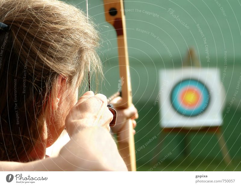Bogenschützin spannt den Bogen und visiert eine Zielscheibe an Freizeit & Hobby Sport Sportler Bogenschießen Schießen feminin Frau Erwachsene Kopf Arme 1 Mensch