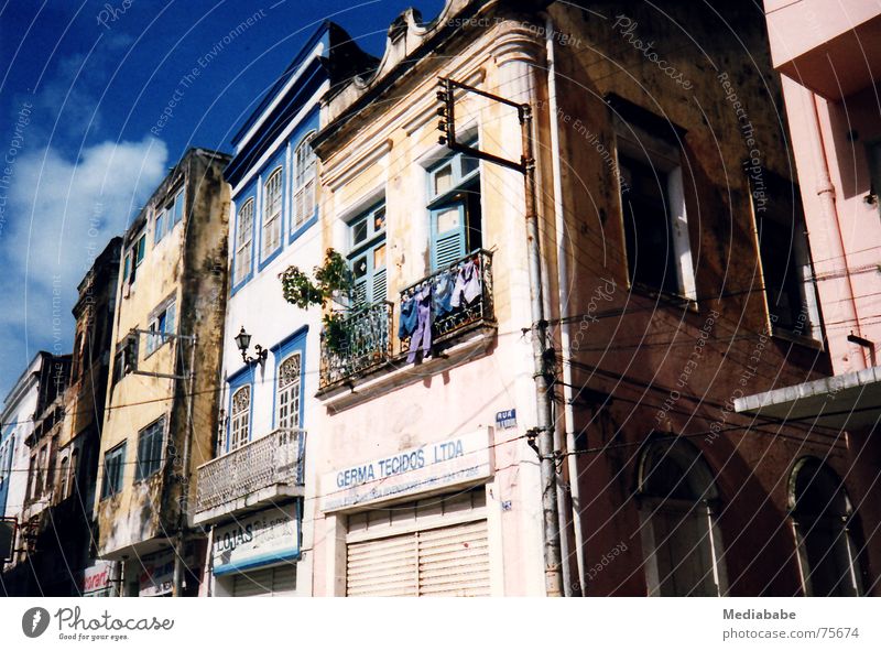 reality bites Brasilien Wäsche Balkon Ferien & Urlaub & Reisen Haus diagonal Dach grell mehrfarbig Wolken Fassade Gebäude Himmel blau sureal bauen colonialstil