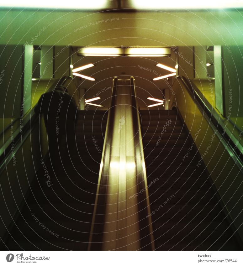 das leben ist eine rolltreppe U-Bahn S-Bahn dunkel Neonlicht Lampe Mann Ruhestand Rolltreppe festhalten steigen Gummi schwarz grün gelb weiß grau schwer Trauer