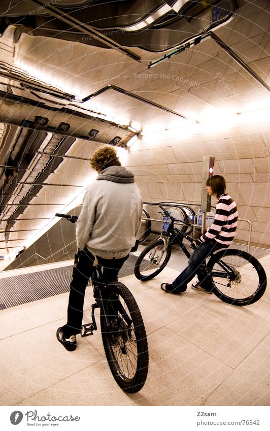 wer fährt als erster? 2 Mountainbike springen fahren Trick Stunt Aktion Spiegel U-Bahn Eisenbahn Rolltreppe Physik stehen lässig Lifestyle Stil Jugendliche