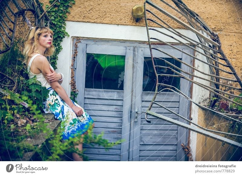 Wann er wohl kommt? feminin Junge Frau Jugendliche 1 Mensch Skulptur Grünpflanze Mauer Wand Tür Kleid blond langhaarig beobachten berühren genießen Blick sitzen